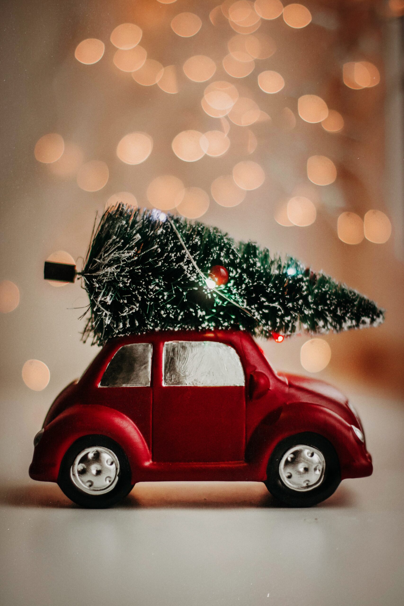 Tiny red car with holiday tree on top