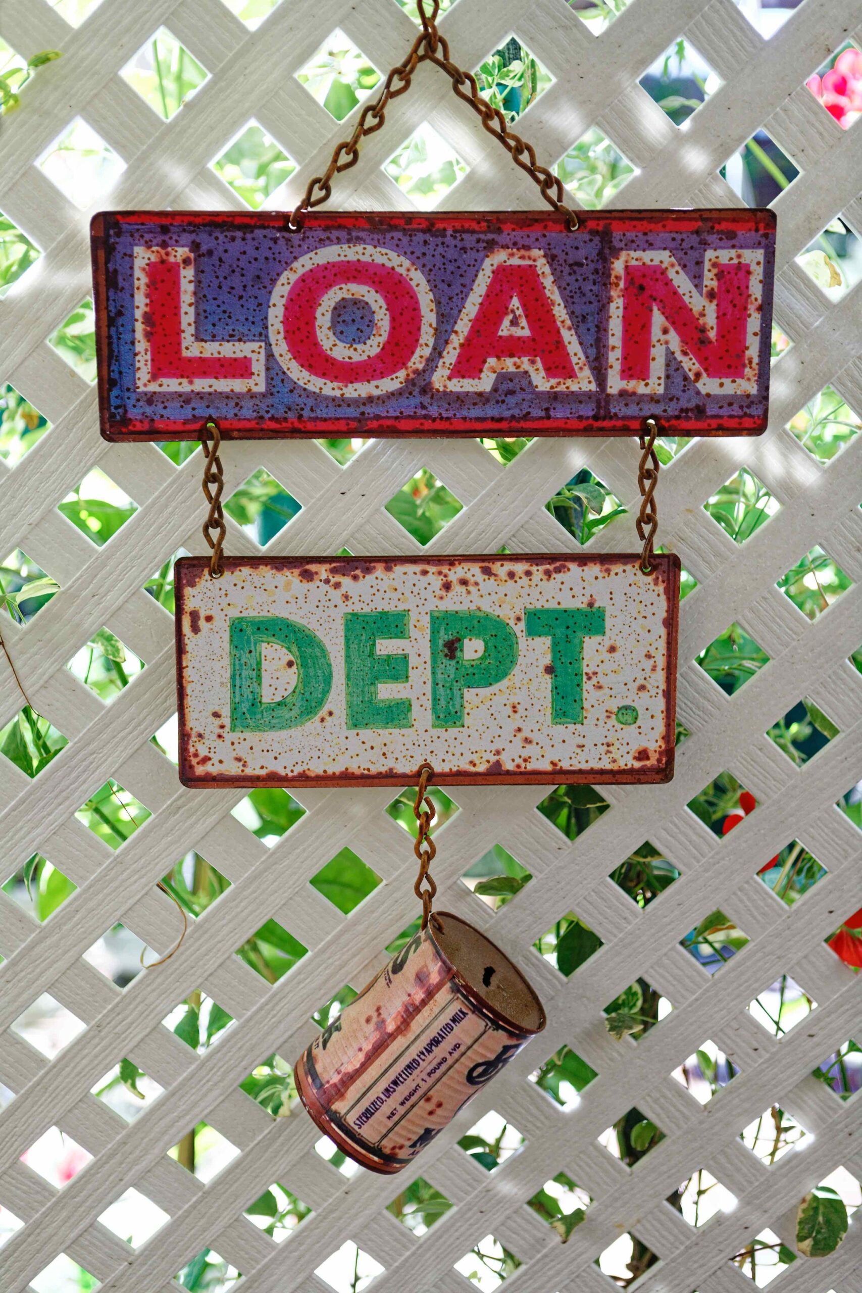 Hanging sign which says "loan department" with tin can beneath it