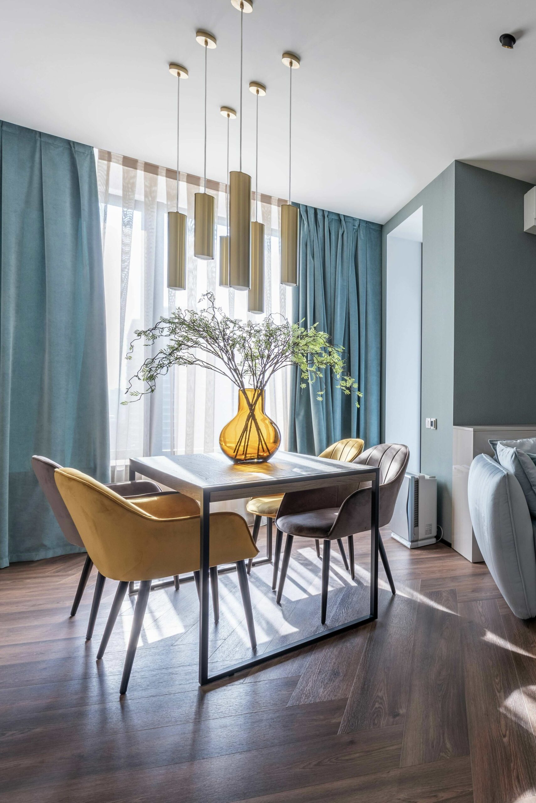 Dining room with turquoise curtains, modern table and gold pendant lights